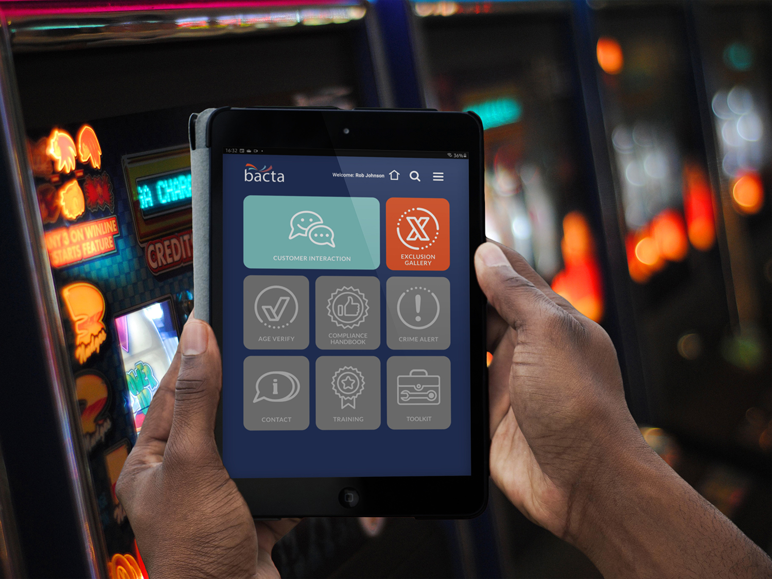 Man holding ipad in arcade with bacta Portal dashboard on screen